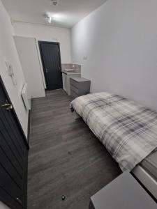 a bedroom with a bed with a plaid blanket at Room On Southall High Street in Southall