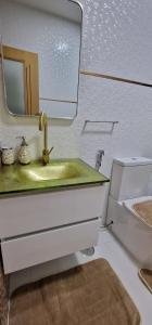 W łazience znajduje się umywalka, lustro i toaleta. w obiekcie SUITES-HOME, CIDADELA w mieście Praia