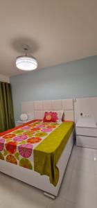 um quarto com uma cama grande e uma colcha colorida em SUITES-HOME, CIDADELA em Praia