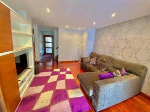un salon avec un canapé et une télévision dans l'établissement Gure Etxetxue - Apartamento duplex muy soleado, à Bermeo