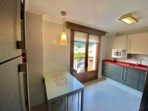 une petite cuisine avec une table et une fenêtre dans l'établissement Gure Etxetxue - Apartamento duplex muy soleado, à Bermeo