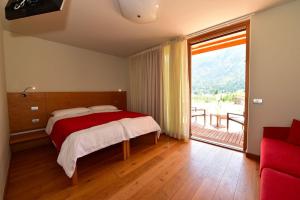 a bedroom with a bed and a large window at Agritur Anselmi in Terzolas