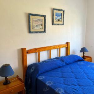 a bedroom with a bed with a blue comforter at Las Dulcineas in La Paloma