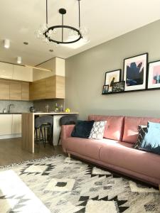 ein Wohnzimmer mit einem Sofa und einer Küche in der Unterkunft Luxury Pearl with Parking place in Holešovice in Prag