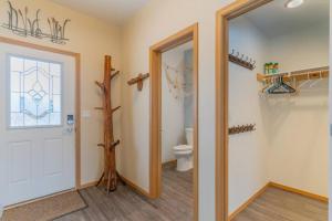 a bathroom with a toilet and a window and a door at Charming Family Haven On the Loop in Fairbanks