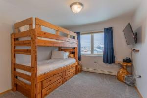a bedroom with a wooden bunk bed and a window at Charming Family Haven On the Loop in Fairbanks