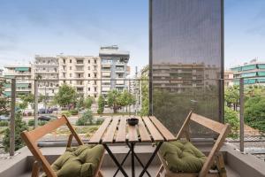 a table and chairs on a balcony with a view of a city at Artsy Urban Loft in Athens in Athens