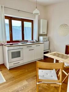 uma cozinha com electrodomésticos brancos, uma mesa e uma cadeira em Bioappartement mit Garten, Waldnähe, Blick ins Inntal 100m em Simbach am Inn