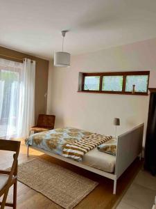 um quarto com uma cama num quarto com uma janela em Bioappartement mit Garten, Waldnähe, Blick ins Inntal 100m em Simbach am Inn