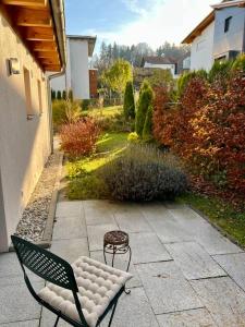 een bank en een kruk op een patio bij Bioappartement mit Garten, Waldnähe, Blick ins Inntal 100m in Simbach am Inn