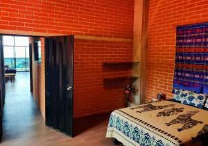 洛佩斯港的住宿－LOFT BEACH 100m2 private apartment，一间卧室设有一张床和砖墙