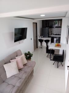 uma sala de estar com um sofá e uma cozinha em Apartamento de lujo , con linda vista, cuarto piso em Cartago