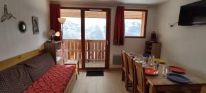 a dining room with a table and chairs and a room with a balcony at Au bon endroit N3 - Appartement 2 pièces 5/7 personnes - proche pistes - Belle vue montagne in Orcières