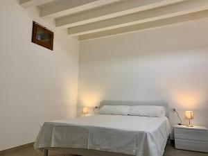 um quarto branco com uma cama branca e 2 candeeiros em CENTRAL HOME CHIOGGIA [in the historic center] em Chioggia