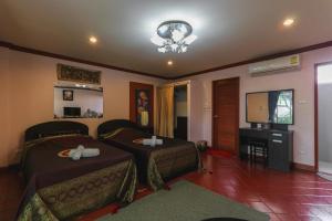 a living room with two beds and a television at The Phen House in Hua Hin