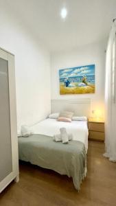 バルセロナにあるSuites4days Sagrada Familia Apartmentのベッドルーム1室(ベッド1台付)が備わります。壁には絵画が飾られています。