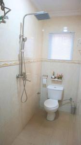 y baño con aseo y ducha. en Sonia Apartments Ikeja, en Lagos