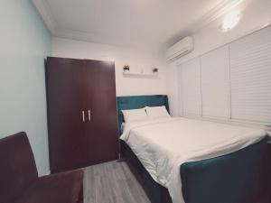 Habitación pequeña con cama y ventana grande. en Sonia Apartments Ikeja, en Lagos
