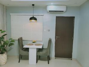 comedor con mesa, sillas y puerta en Sonia Apartments Ikeja, en Lagos