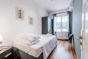 a bedroom with a bed with white sheets and a window at Indipendenza Mansion City Centre in Bologna