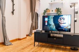 ein Wohnzimmer mit einem Flachbild-TV auf einem Stand in der Unterkunft Indipendenza Mansion City Centre in Bologna