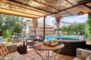 eine Außenterrasse mit einem Whirlpool und einem Pool in der Unterkunft Villa ilusions en Olivella, Sitges, Barcelona in Olivella