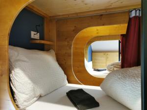 Cette chambre comprend un lit avec un miroir circulaire. dans l'établissement Hostel des Combes, à Les Combes