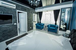 a bedroom with two blue chairs and a bed at Apartament Sweet Luxury in Galaţi