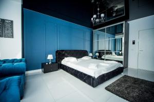 Dormitorio azul con cama y pared azul en Apartament Sweet Luxury en Galaţi