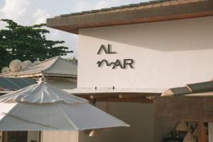 un panneau indiquant un maar sur un bâtiment avec un parapluie dans l'établissement AL MAR SUÍTES, à Praia do Forte