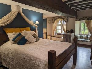 a bedroom with a large bed with a canopy at Chateau De Montmagner in Arnac-la-Poste