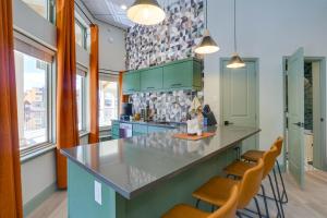 a kitchen with green cabinets and a counter with stools at Mtn and Lake Views Chic Keystone Studio in Keystone