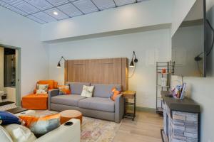 a living room with a couch and an orange chair at Mtn and Lake Views Chic Keystone Studio in Keystone