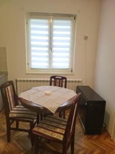 a table and chairs in a room with a window at Apartman LAZAR I VIKTOR in Vrnjačka Banja