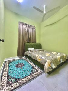 Un dormitorio con una cama y una alfombra en el suelo. en D'PAYA HOMESTAY, en Bachok