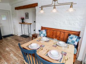 a dining room with a wooden table and chairs at Pensarngerrig in Llandysul