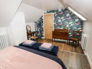 a bedroom with a bed and a dresser in a room at Pensarngerrig in Llandysul