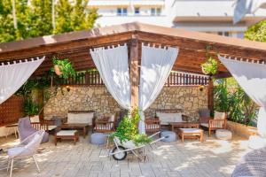 een patio met tafels en stoelen en witte gordijnen bij Hotel Euromar in Marina di Massa