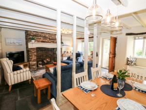uma sala de jantar e sala de estar com um sofá e uma mesa em Alexander's Cottage em Kingsbridge