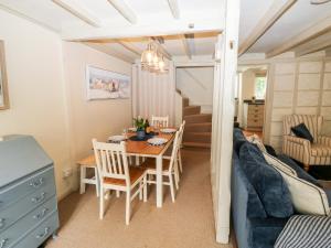 uma sala de jantar e sala de estar com uma mesa e um sofá em Alexander's Cottage em Kingsbridge
