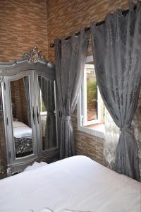 a bedroom with a bed and a window with curtains at Ghazalle oasis Hotel GB in El Biar