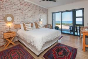 a bedroom with a bed and a brick wall at Spookdraai B&B in Agulhas