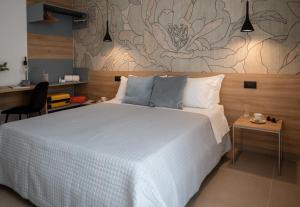 Un dormitorio con una gran cama blanca y una mesa en Incanto B&B Cefalù, en Cefalú