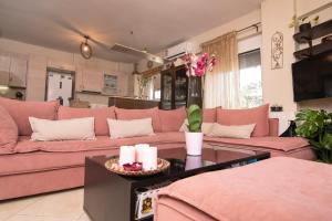 - un salon avec un canapé rose et une table dans l'établissement Maria's Double Room, à Spáta