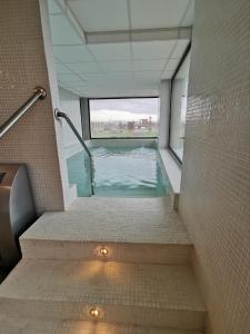 - une piscine dans un bâtiment avec fenêtre dans l'établissement Los Flamencos Sea View Apartment, à Carthagène