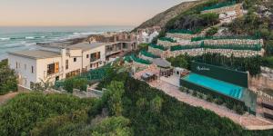 a building on a hill next to the ocean at Spookdraai B&B in Agulhas