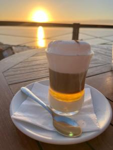 a cup of coffee on a plate with a spoon at Gran Relax Alcala Appartement in Alcalá