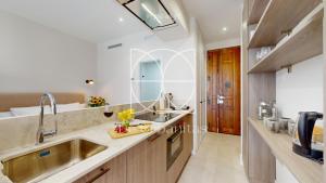 eine Küche mit einem Waschbecken und einem großen Spiegel in der Unterkunft Santa Cruz in Madrid + 26 Fotos