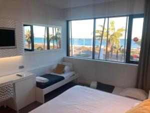 a bedroom with two beds and a view of the beach at SoBlue Hôtel in Antibes