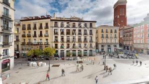 een groep mensen die door een straat lopen bij Santa Cruz in Madrid